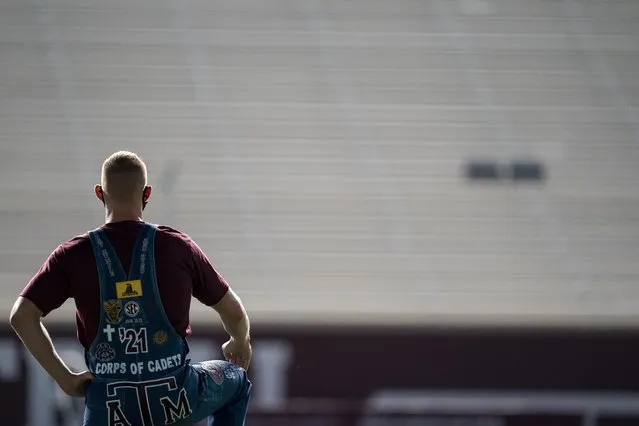 Texas A&M University Yell Leader Jacob Huffman takes a knee while looking over the empty stands at Kyle Field in College Station, Texas during the first Midnight Yell Practice this season early Saturday, September 26, 2020. Due to Coronavirus restrictions, the Texas A&M Band were the only crowd allowed in the normally packed stands for the traditional game day event in College Station, Texas. (Photo by Sam Craft/Pool Photo via AP Photo)