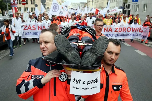 A march of the health workers organized by the Agreement Medical Professions pass through the streets of Warsaw, Poland, 24 September 2016. The march was attended by nine members of the national union of doctors, as well as nurses and midwives, medical technicians, physiotherapists. The protesters are demanding among other things, a higher minimum wage. (Photo by Rafal Guz/EPA)