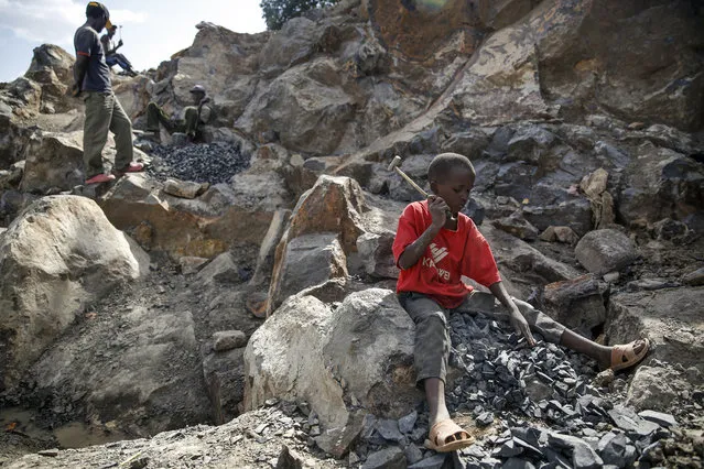 Kevin Mutinda, 7, works breaking rocks with a hammer along with his older sisters and mother, who says she was left without a choice after she lost her cleaning job at a private school when coronavirus pandemic restrictions were imposed, at Kayole quarry in Nairobi, Kenya Tuesday, September 29, 2020. (Photo by Brian Inganga/AP Photo)