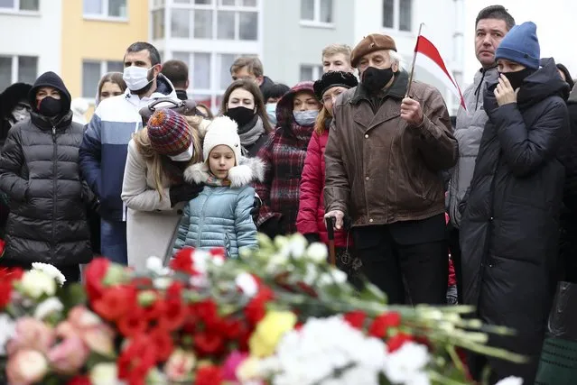 People gather to honor 31-year-old Raman Bandarenka, who died Thursday at a Minsk hospital after several hours of surgery due to serious injuries, in Minsk, Belarus, Friday, November 13, 2020. Thousands of people have rallied in Belarus on Friday following the death of a 31-year-old opposition supporter who died in a hospital after he was reportedly beaten by security forces, and the European Union condemned the continued violent crackdown that Belarusian authorities have waged on peaceful protesters. (Photo by AP Photo/Stringer)