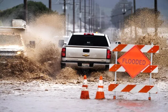 Cars and trucks drive through flooded streets as an atmospheric river storm slams California in Salinas, California on Friday March 10, 2023. (Melina Mara/The Washington Post)