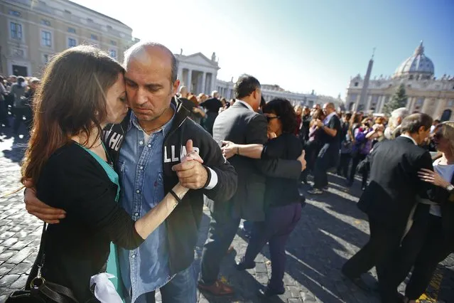 Couples dance in front of Saint Peter's basilica at the Vatican December 17, 2014. (Photo by Tony Gentile/Reuters)