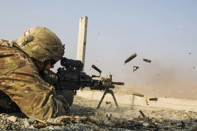 A U.S. soldier from the 3rd Cavalry Regiment is seen as he fires a squad automatic weapon during a training mission near forward operating base Gamberi, in the Laghman province of Afghanistan December 15, 2014. (Photo by Lucas Jackson/Reuters)