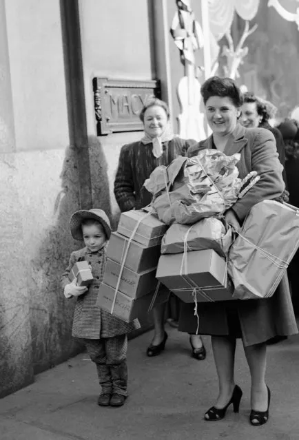 Mrs.Frances Corless her daughter “Chickie” are loaded down with bundles after doing some last minute shopping at Macy's on Christmas Eve in New York, December 24, 1946. (Photo by Carl Nesensohn/AP Photo)