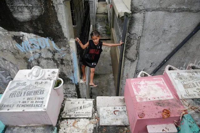 A child balances between graves as she follows the funeral procession for a man killed in a police anti-drugs operation, in Manila, Philippines October 15, 2016. (Photo by Damir Sagolj/Reuters)