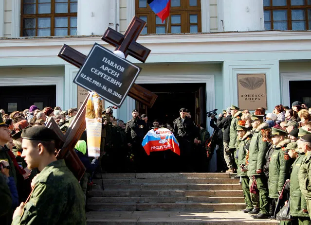 Members of the self-proclaimed Donetsk People's Republic forces carry the coffin of Russian separatist commander Arseny Pavlov, known by the nom de guerre “Motorola”, who was blown up in the lift of his apartment building on October 16, during his funeral ceremony outside the Donbass Opera in Donetsk, Ukraine, October 19, 2016. (Photo by Alexander Ermochenko/Reuters)