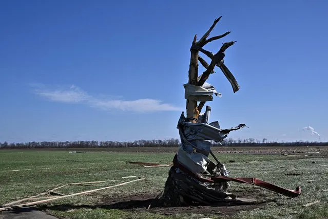 Pieces of a hangar are seen wrapped around a tree at Robinson Municipal Airport, two days after a tornado hit Palestine, Illinois, U.S., April 2, 2023. (Photo by Jon Cherry/Reuters)