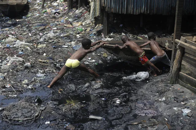 Children pull out a canoe in the floating slum of Makoko in Lagos, Nigeria, Saturday March 21, 2020. Lockdowns have begun in Africa as coronavirus cases rise above 1,000, while Nigeria on Saturday announced it is closing airports to all incoming international flights for one month in the continent's most populous country. Concerns are mounting for the welfare of Nigeria's most vulnerable community on stilts over spread of Covid-19 with little or no chances for social distancing as confirmed positive cases of the disease is on the rise. (Photo by Sunday Alamba/AP Photo)