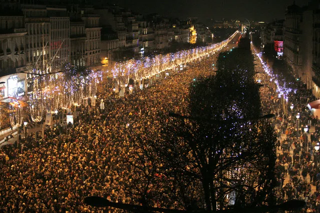 People gather on the Champs-Elysees avenue in Paris before celebrating the New Year on December 31, 2014. (Photo by Matthieu Alexandre/AFP Photo)