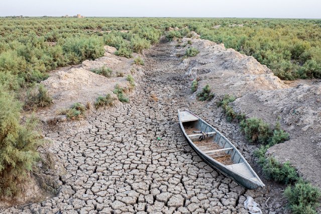 This aerial view shows a traditional boat stranded in a dried-up marsh in the drought-striken Chibayish marshes in Iraq's southern Dhi Qar province on August 19, 2025. (Photo by Asaad Niazi/AFP Photo)