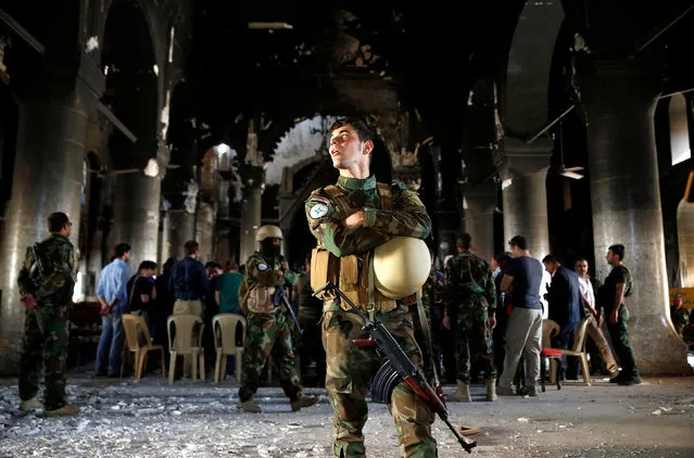 Iraqi Christian soldiers attend the first Sunday mass at the Grand Immaculate Church since it was recaptured from Islamic State in Qaraqosh, near Mosul in Iraq October 30, 2016. (Photo by Ahmed Jadallah/Reuters)