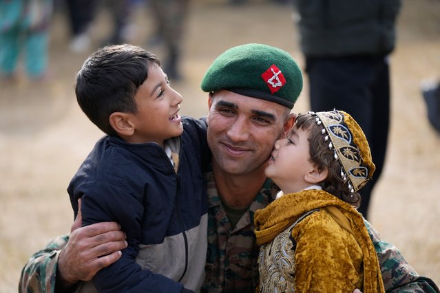 Kashmiri children kiss their uncle, a newly recruited soldier of the Jammu and Kashmir Light Infantry (JKLI), during a passing-out parade at training center Dansal, outskirts of Jammu, India Monday, December 1, 2025. (Photo by Channi Anand/AP Photo)