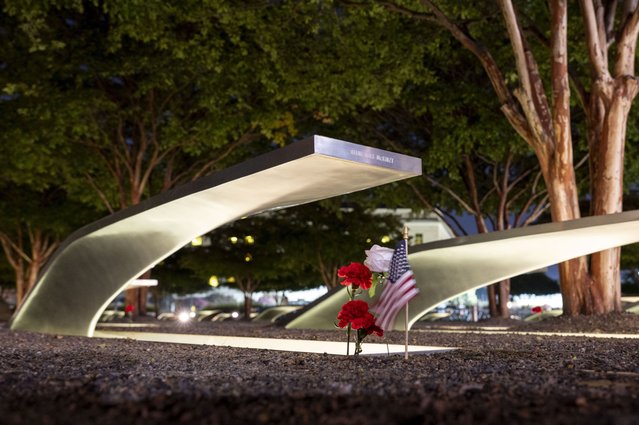 Flowers and a flag adorn one of the memorial benches outside the Pentagon before the start of a dawn 9/11 remembrance ceremony on Wednesday, September 11, 2024 in Washington. (Photo by Kevin Wolf/AP Photo)