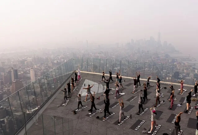 People attend a morning yoga class on The Edge observation deck as a haze caused by smoke from wildfires burning in Canada hangs over Manhattan in New York, USA, 07 June 2023. An air quality alert was issued for the whole of New York City as a result of the smoke, which affects large portions of the northeastern United States. (Photo by Justin Lane/EPA)