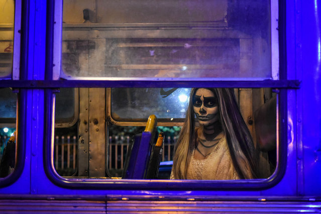 A lady dressed in a ghost costume poses for the camera inside a public bus during a contest ahead of the Halloween celebration in Kolkata, India, on October 28, 2024. (Photo by Debarchan Chatterjee/NurPhoto via Getty Images)