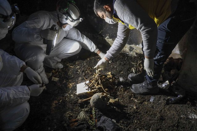 Syrian civil defense workers known as the White Helmets collect human remains found in two separate basements in Sbeneh, Syria, on Tuesday, January 28, 2025. They said the charred remains belong to at least 26 victims of the Bashar al-Assad regime. Since Assad fled the country on December 8 following the collapse of his regime, Syrians are starting to uncover mass graves across the country. (Photo by Omar Albam/AP Photo)