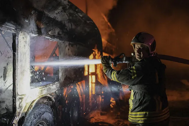 In this photo provided by the Ukrainian Emergency Situations Ministry, a firefighter tries to put out fire caused by fragments of a Russian rocket after it was shot down by air defense system during the night Russian rocket attack in Kyiv, Ukraine, early Tuesday, May 16, 2023. (Photo by Ukrainian Emergency Situations Ministry via AP Photo)