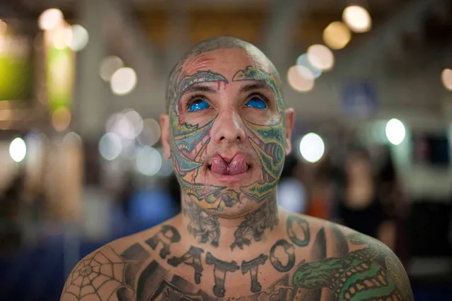 Brazilian tattoo artist who goes by the name “Rattoo”, a play on the Portuguese word “rato” that means “rat”, poses for pictures as he shows off his skin tattoos, his tattooed eyes and his modified split tongue during Tattoo Week events in Sao Paulo, Brazil, Friday, July 19, 2013.  Tattoo Week is an annual event that attracts international tattoo artists and body piercing artists as well as consumers. (Photo by Andre Penner/AP Photo)
