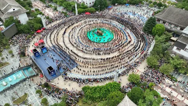 Aerial photos shows tourists experience the Miao ethnic water drum dance at the Yangasha Cultural Festival in Qiandongnan, Guizhou province, China, July 23, 2023. (Photo by Costfoto/NurPhoto via Getty Images)