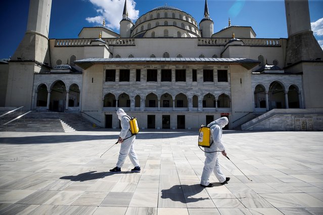 Municipality workers in protective suits disinfect courtyard of the Kocatepe Mosque to prevent the spread of the coronavirus disease (COVID-19), during the holy fasting month of Ramadan in Ankara, Turkey on April 15, 2021. (Photo by Cagla Gurdogan/Reuters)