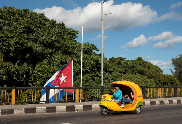 A coco-taxi drives past a Cuban flag at half mast, following the announcement of the death of Cuba's former President Fidel Castro, in Havana, Cuba, November 27, 2016. (Photo by Reuters/Stringer)