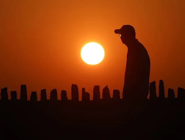 As exceptionally warm weather moves into the upper Midwest, a pedestrian walks at sunset, in Oconomowoc, Wis., Tuesday, August 22, 2023. (Photo by John Hart/Wisconsin State Journal via AP Photo)