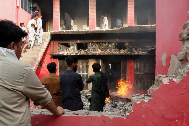 People gather at a church building vandalized by protesters in Jaranwala, Pakistan on August 16, 2023. (Photo by Fayyaz Hussain/Reuters)