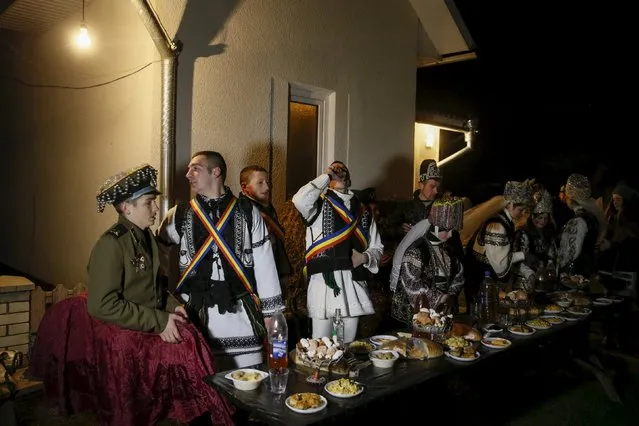 Local residents, dressed in costumes, gather at a festive table before the celebrations for Malanka holiday in the village of Krasnoilsk in Chernivtsi region, Ukraine, January 13, 2016. (Photo by Valentyn Ogirenko/Reuters)