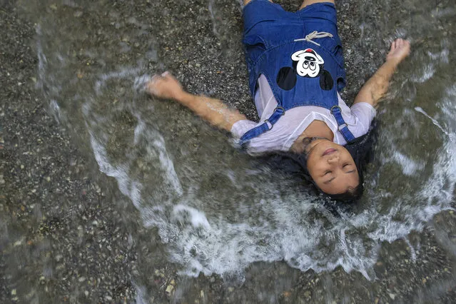 A girl plays in a flooded street at Srimahaphot district in Prachin Buri September 29, 2013. More than 2 million people have been affected by flooding in Thailand, officials said on Monday, while authorities warned that more heavy rains could inundate the country's northeast but offered assurances that there would be no repeat of 2011 when floodwaters reached central industrial areas and near Bangkok. (Photo by Athit Perawongmetha/Reuters)