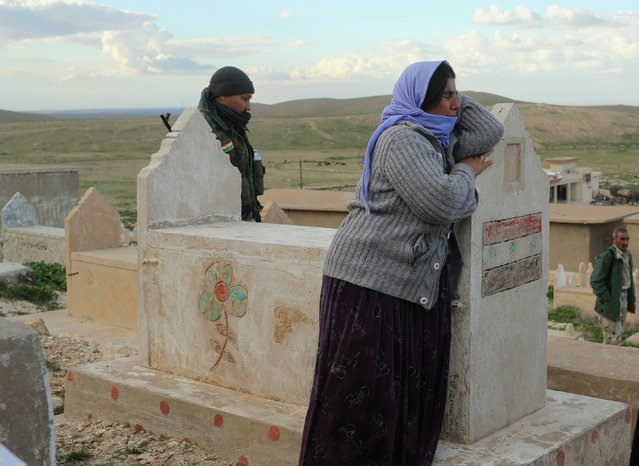 A Kurdish Yazidi woman, relative of a Peshmerga fighter killed in a suicide attack in Sinjar province, mourns as Peshmerga fighters bury the body at Mazar Sharaf Eldin, a sacred and a cemetery area for the Yazidi minority, north of Sinjar, March 2, 2015. A number of Peshmerga were killed and others injured after two suicide car bombs attacks targeted a building the Peshmerga were using for fighting, according to Peshmerga officials. REUTERS/Asmaa Waguih