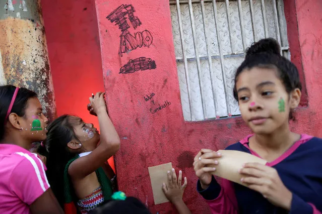 Children write letters during a visit by Santa Claus to residents of the slum of Petare in Caracas, Venezuela, December 11, 2016. (Photo by Ueslei Marcelino/Reuters)