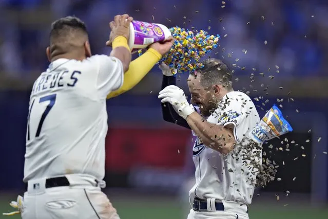 Tampa Bay Rays' Brandon Lowe is covered with gum and sunflower seeds by Isaac Paredes (17) after his walk off single off Colorado Rockies relief pitcher Brent Suter scored Osleivis Basabe during the 10th inning of a baseball game Wednesday, August 23, 2023, in St. Petersburg, Fla. (Photo by Chris O'Meara/AP Photo)