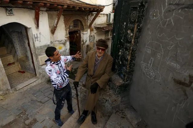 Residents joke with each other in the old city of Algiers Al Casbah, Algeria December 6, 2015. The Algiers Casbah is a UNESCO World heritage site that includes the Sidi Ramdane mosque and former fortress, 10 centuries old. Decay from the passing years, as well as earthquake damage in 2003, leads some to consider a move to modern apartments with financial backing from the government. Others refuse to leave a neighbourhood they have called home for decades. (Photo by Zohra Bensemra/Reuters)