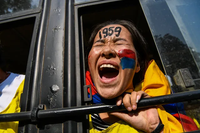 An exiled Tibetan youth shout slogans from a police bus as she protests against a visit of Chinese leaders to India in New Delhi on October 23, 2018. A delegation including China's minister of public security Zhao Kezhi and other high-level ministers were on a visit to India to meet Indian home minister Rajnath Singh and Indian Prime Minister Narendra Modi. (Photo by Chandan Khanna/AFP Photo)