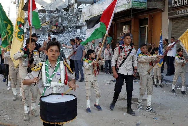 A Scout marching band pass a building destroyed by an Israeli airstrike, during a protest against a march by Jewish ultranationalists through east Jerusalem, along the streets of Gaza City, Tuesday, June 15, 2021. (Photo by Adel Hana/AP Photo)