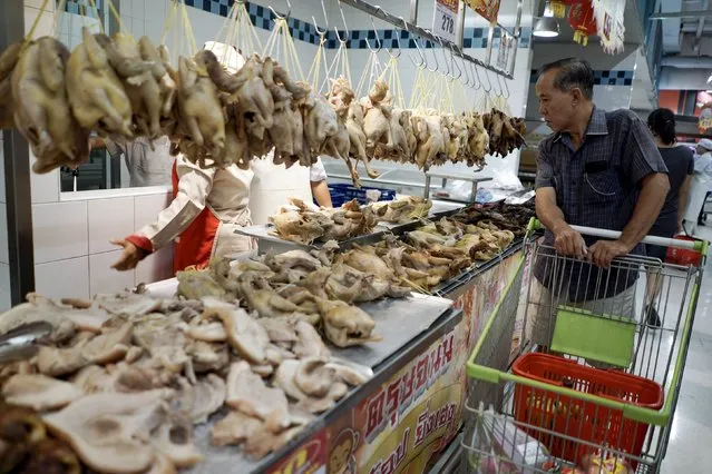 A man looks at roast chickens for sale at a shopping mall ahead of the Chinese Lunar New Year celebrations in Bangkok, Thailand, February 6, 2016. (Photo by Athit Perawongmetha/Reuters)