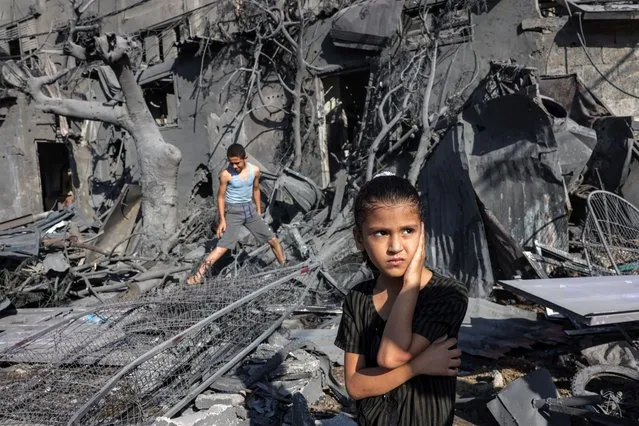 A girl looks on as she stands by the rubble outside a building that was hit by Israeli bombardment in Rafah in the southern Gaza Strip on October 31, 2023 amid ongoing battles between Israel and the Palestinian Hamas movement. (Photo by Mohammed Abed/AFP Photo)