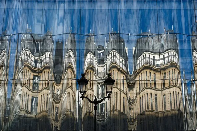 Haussmann architecture buildings are reflected on the facade of Samaritaine department store in central Paris on October 10, 2023. (Photo by Dimitar Dilkoff/AFP Photo)