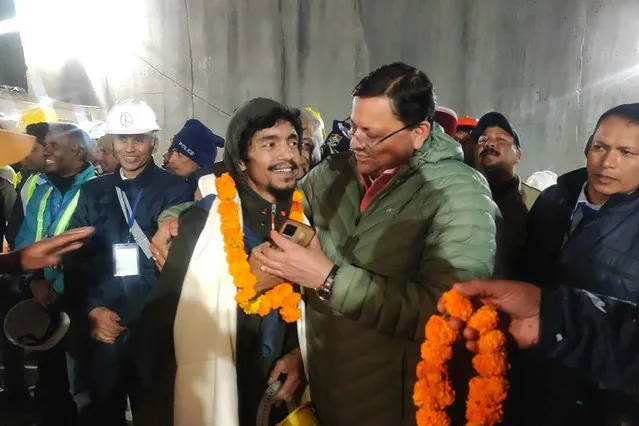 This handout photo provided by the Uttarakhand State Department of Information and Public Relations shows Pushkar Singh Dhami, right, Chief Minister of the state of Uttarakhand, greeting a worker rescued from the site of an under-construction road tunnel that collapsed in Silkyara in the northern Indian state of Uttarakhand, India, Tuesday, November 28, 2023. Dhami said eight workers were rescued so far on Tuesday. The laborers are being pulled out through a passageway made of welded pipes which rescuers previously pushed through dirt and rocks. (Photo by Uttarakhand State Department of Information and Public Relations via AP Photo)