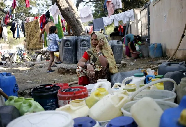 A woman waits to fill water in her containers from a municipal tap in New Delhi, India, February 21, 2016. (Photo by Anindito Mukherjee/Reuters)