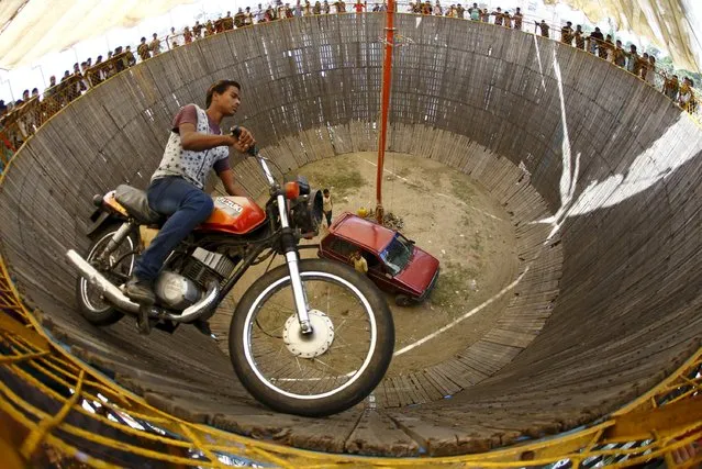 A stuntman rides a motorcycle inside the “Well of Death” attraction during a fair in Bhaktapur April 20, 2015. (Photo by Navesh Chitrakar/Reuters)