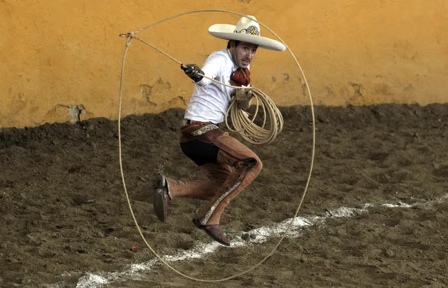 A charro performs the “floreo de reata” during the Charro Day celebrations in Guadalajara, Jalisco state, Mexico, on September 14, 2021. Charreria was declared Intangible Cultural Heritage of Humanity by UNESCO. (Photo by Ulises Ruiz/AFP Photo)