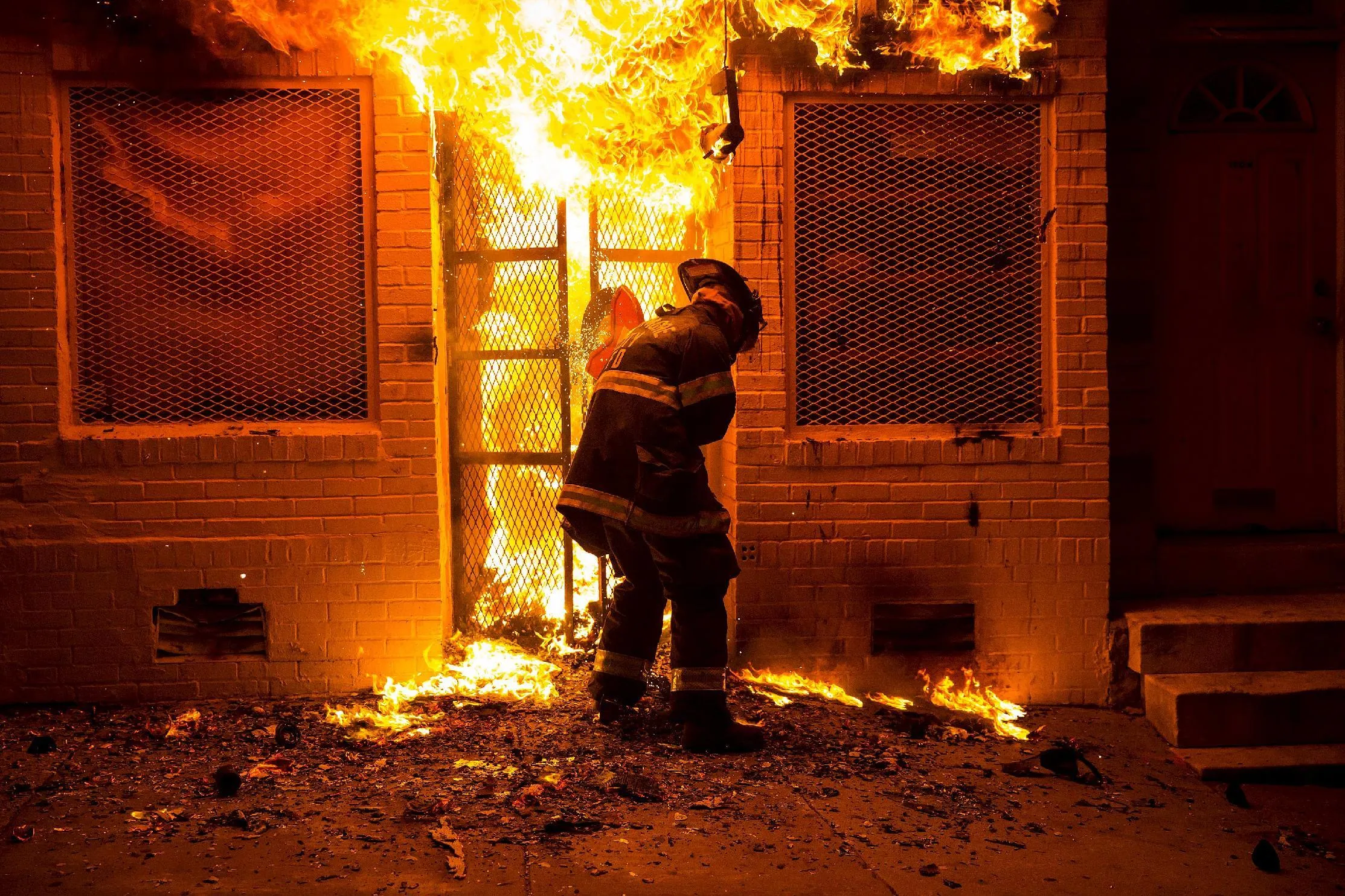 Сгорела двери. Человек в горящем окне. Пожарный заходит в горящий дом. Поджог. Поджог магазина.