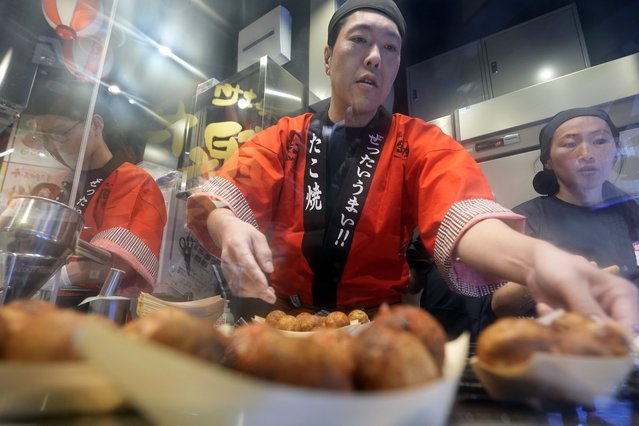 Staff prepare “takoyaki” or octopus dumplings at “Toyosu Senkyaku Banrai”, an Edo Period-themed hot spring complex on media preview event at Toyosu Market Monday, January 29, 2024, in Tokyo. (Photo by Eugene Hoshiko/AP Photo)