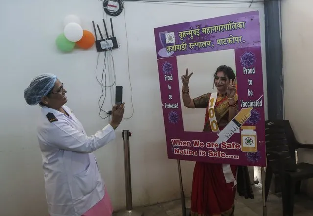 Health workers celebrate with vaccine beneficiaries India administering 1 billion doses of COVID-19 vaccine, at Rajawadi hospital in Mumbai, India, Thursday, October 21, 2021. (Photo by Rajanish Kakade/AP Photo)
