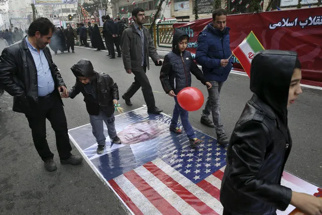 Iranians march on a portrait of U.S. President Donald Trump and the picture of U.S. flag in an annual rally commemorating the anniversary of the 1979 Islamic revolution, which toppled the late pro-U.S. Shah, Mohammad Reza Pahlavi, in Tehran, Iran, Friday, February 10, 2017. (Photo by Vahid Salemi/AP Photo)