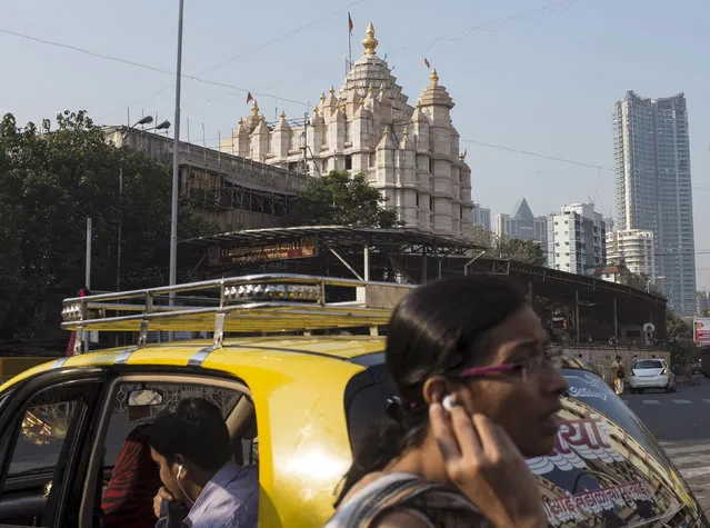 Commuters get out of a taxi in front of Shree Siddhivinayak Ganapati Temple in Mumbai in this March 12, 2015 file photo. (Photo by Danish Siddiqui/Reuters)