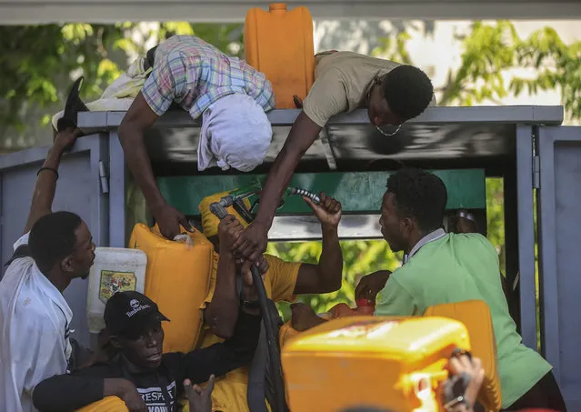 People push as they try to get their gallons filled at a gas station in Port-au-Prince, in Port-au-Prince, Haiti, Thursday. November 4, 2021. (Photo by Joseph Odelyn/AP Photo)