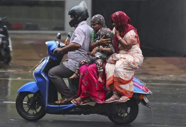 People ride a motorcycle in the rain in Hyderabad, India, Saturday, November 20, 2021. (Photo by Mahesh Kumar A./AP Photo)