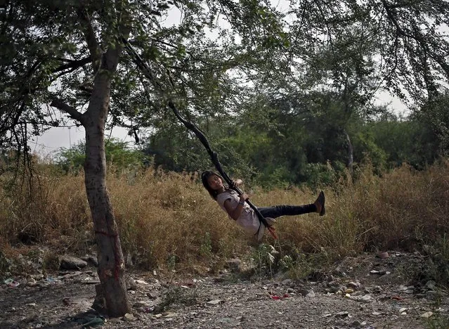 A girl plays on a swing suspended from a tree on a hot summer day in New Delhi, India, May 11, 2015. (Photo by Anindito Mukherjee/Reuters)